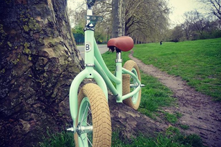 balance bike leaning against a tree