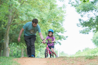 father teaching a child to ride