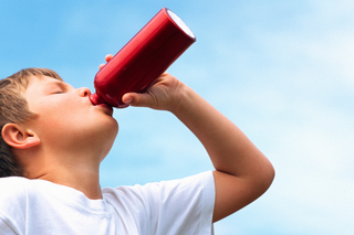 child drinking from reusable water bottle