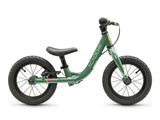 A green balance bike with black tires, saddle, and handlebars, featuring the brand name 'ACADEMY' printed vertically on the frame, shown against a plain white background.
